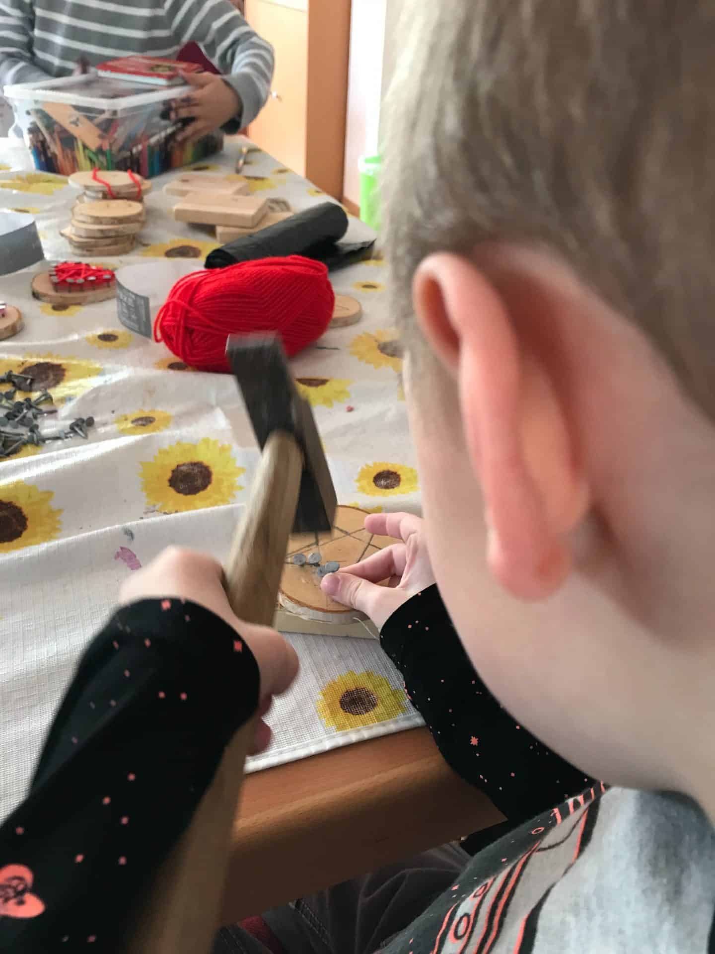 Kinderbetreuung in der FeBg: Ein Kind arbeitet mit einem Hammer